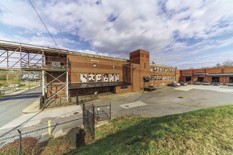 The historic brick Plyler Supply building with the PSC sign, seen from Ivy Avenue